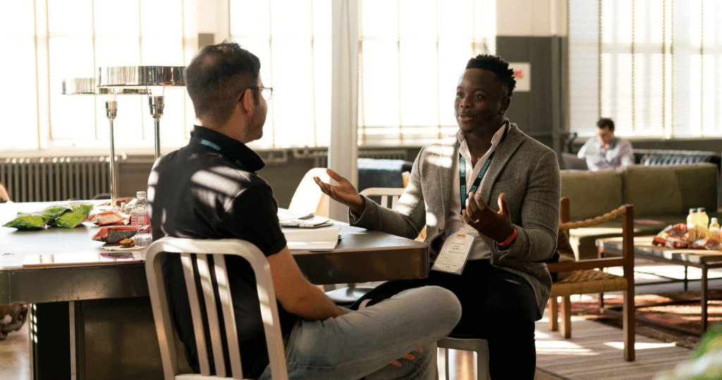 two men talking sitting at a desk
